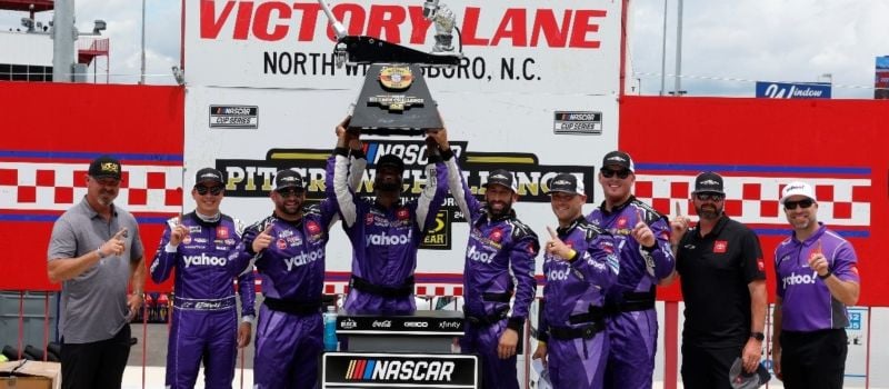 The winning Joe Gibbs Racing pit crew, including front tire changer Blake Houston, tire carrier Jacob Holmes, jackman Derrell Edwards and fueler Peyton Moore, celebrate their second consecutive NASCAR Pit Crew Challenge victory at North Wilkesboro Speedway in 2024’s Pit Crew Challenge. 